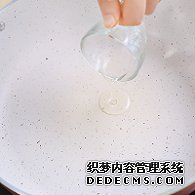 步驟圖:電陶爐開大火，煎炒鍋中倒入少許油。