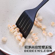 步驟圖:油熱后倒入蝦仁，用鍋鏟翻炒2分鐘至變色，盛出碗中備